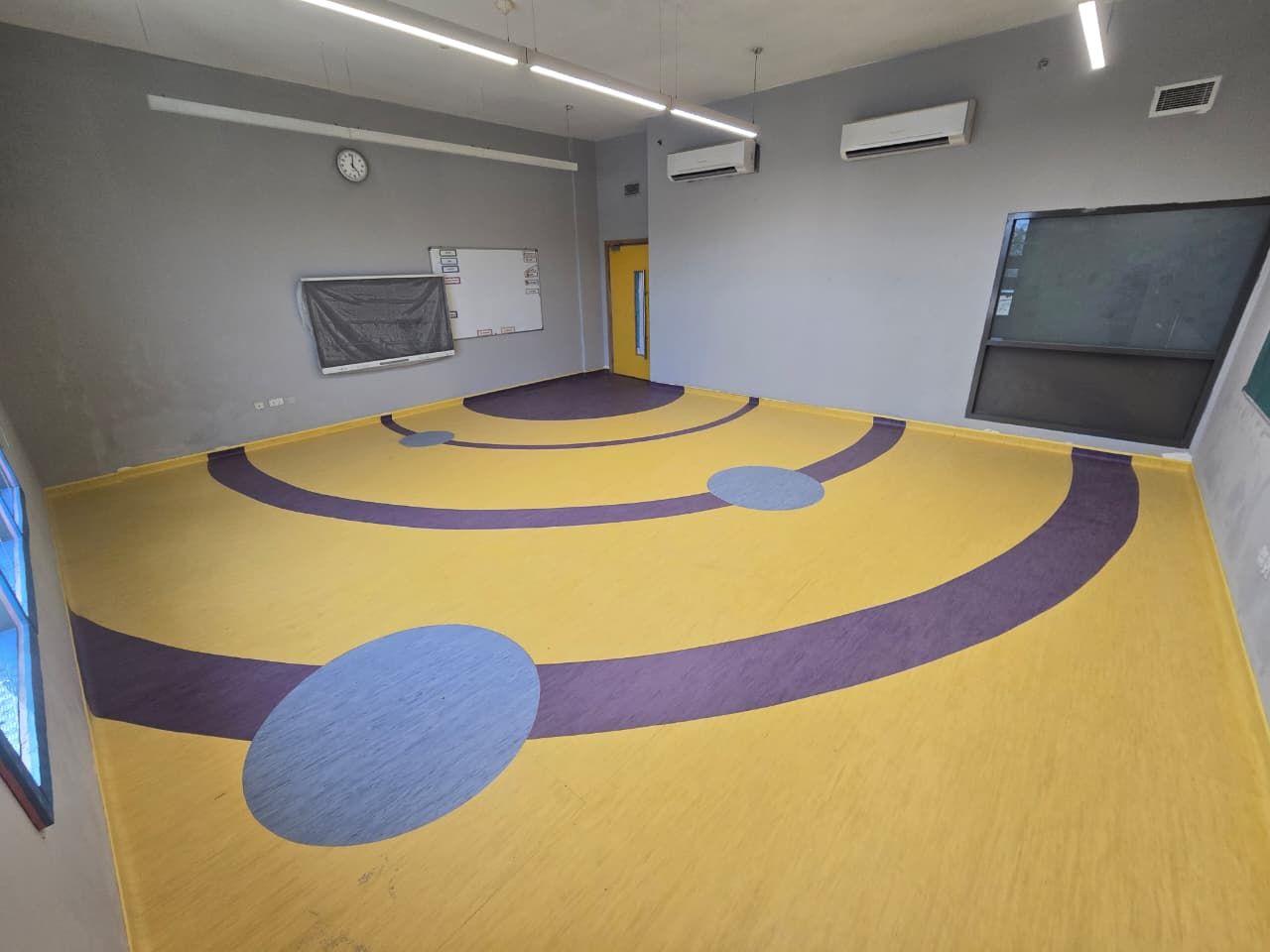 Classroom vinyl flooring in yellow and purple with inlaid pattern