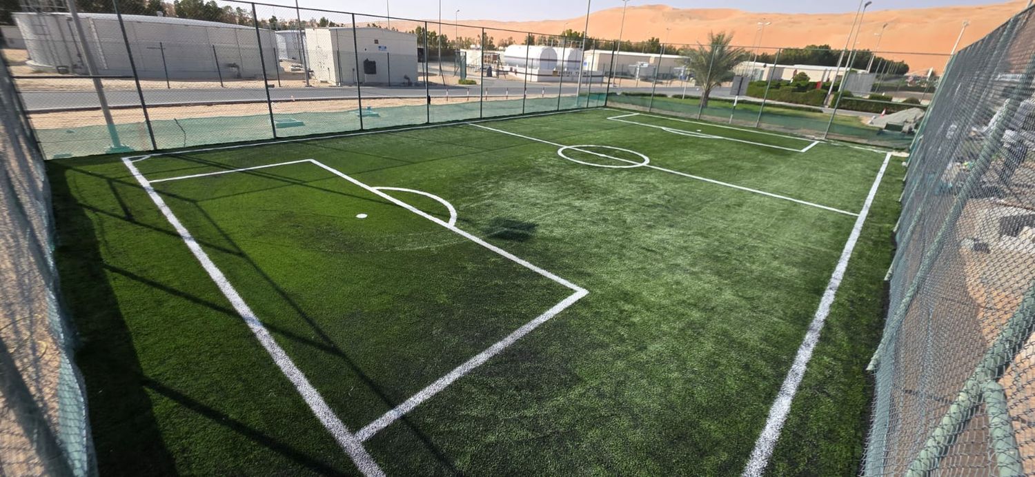 Fenced artificial turf football pitch with goal areas marked