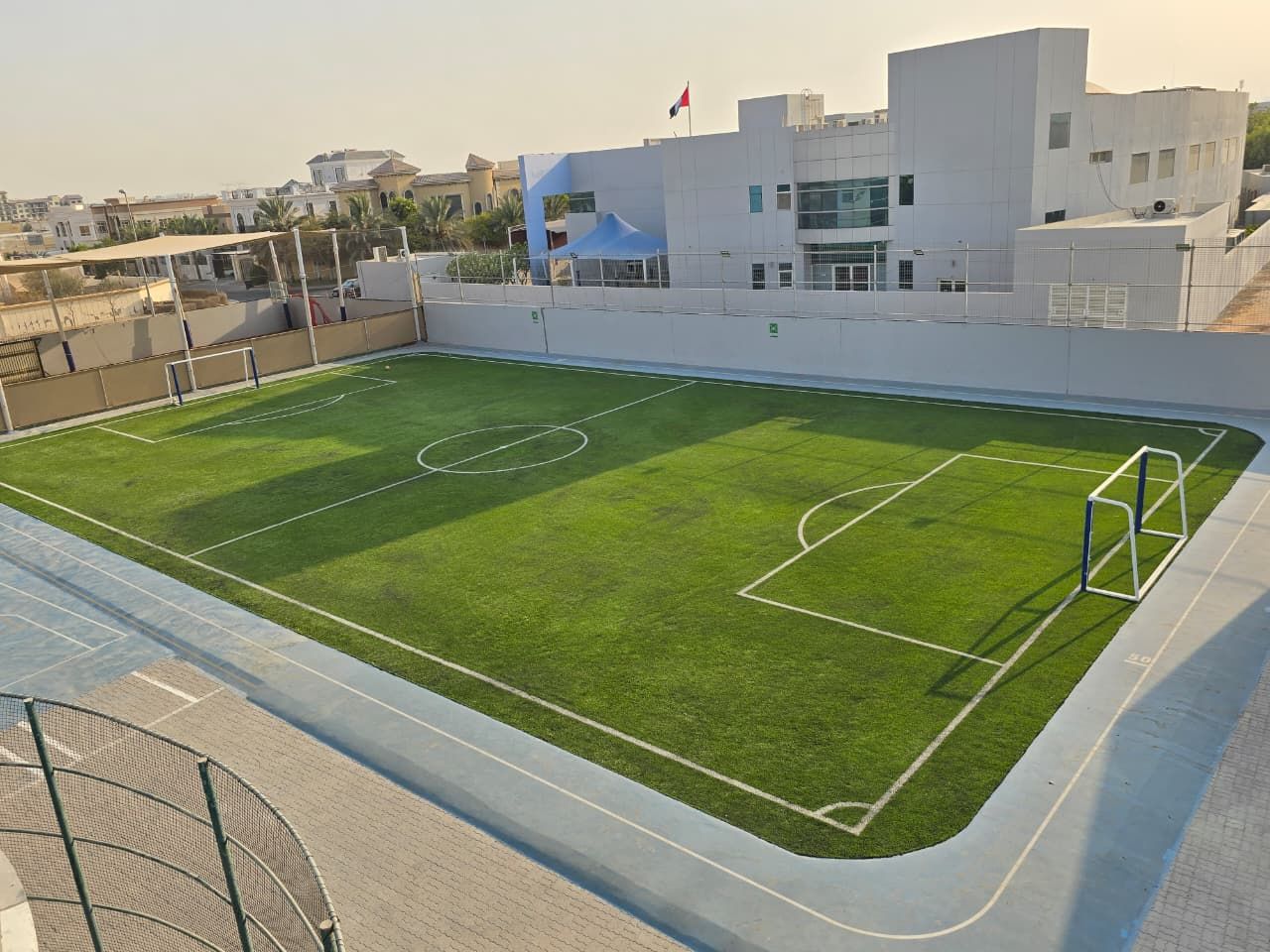 Rooftop artificial turf football pitch with goals and perimeter walkway