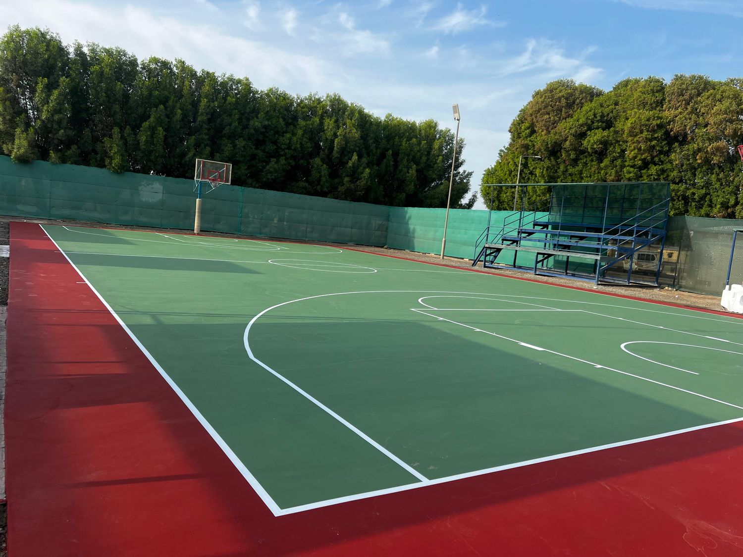 School basketball court in green and red acrylic with spectator stand