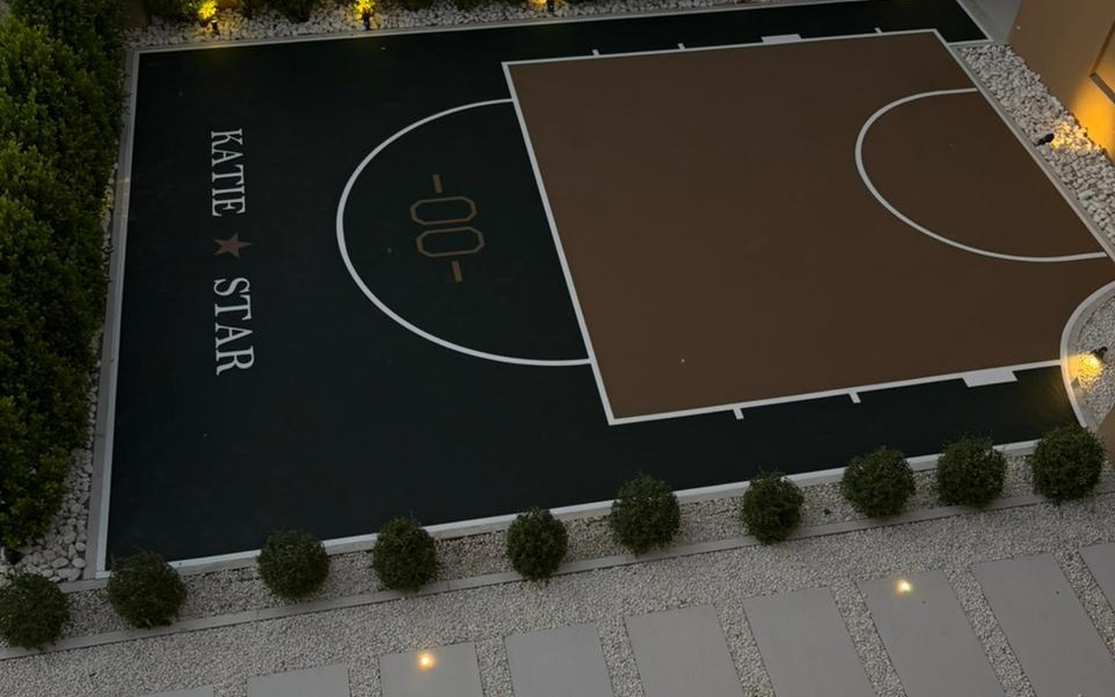 Half basketball court built in a private villa garden with feature lighting