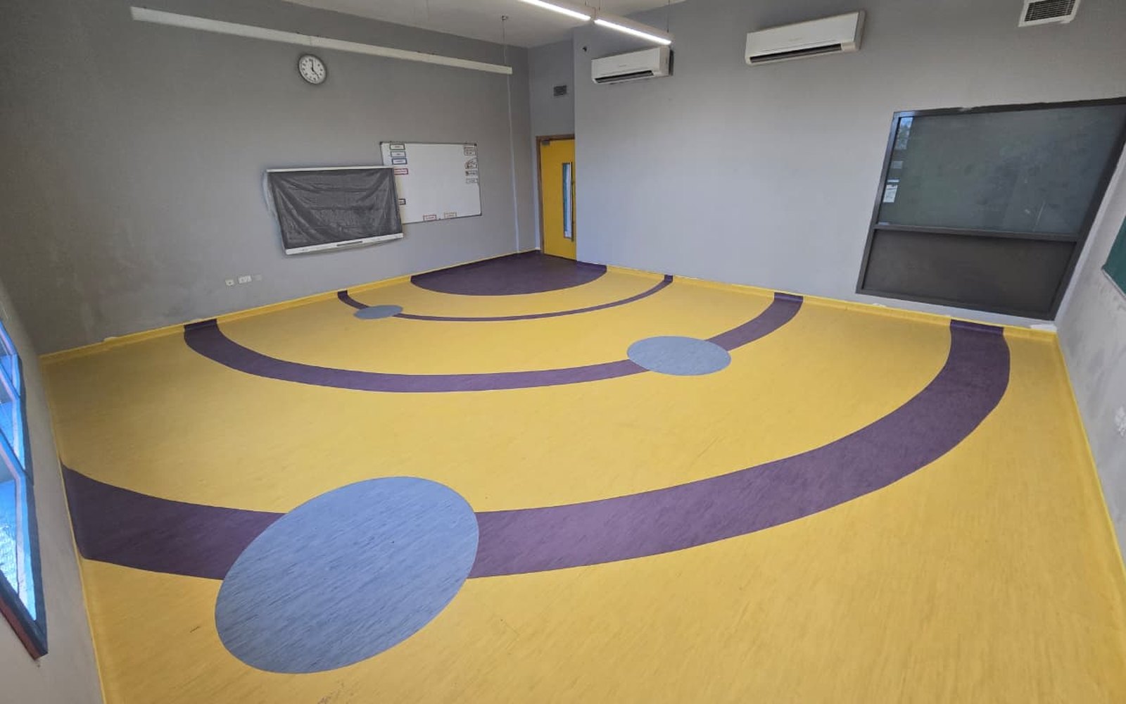Custom patterned vinyl flooring installed in a school activity room