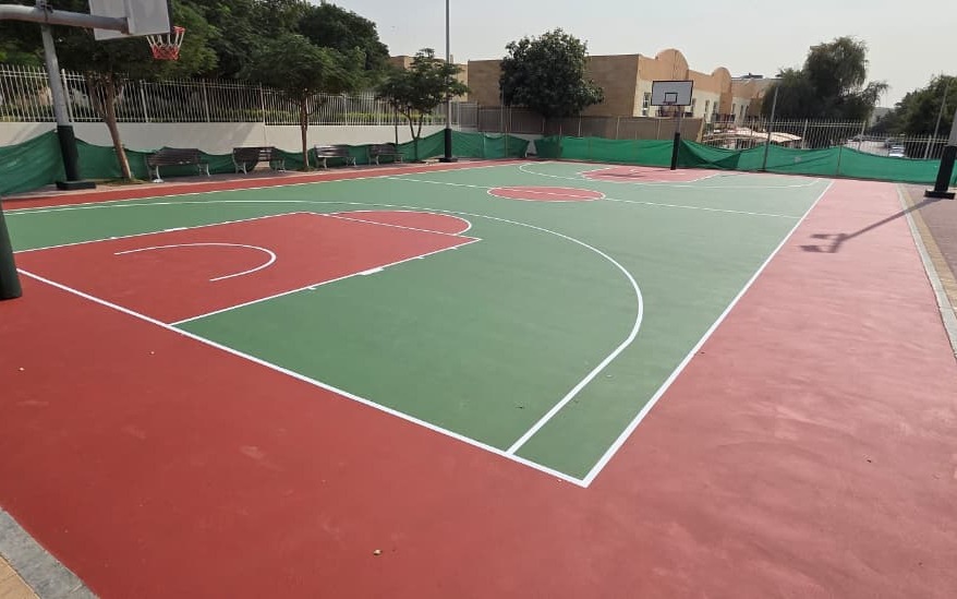 Green and red acrylic outdoor basketball court with white line markings